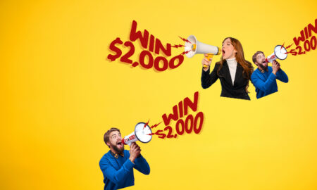 Bright yellow ad featuring three people with megaphones shouting 'WIN $2,000' for a prize promotion (advertising banner).